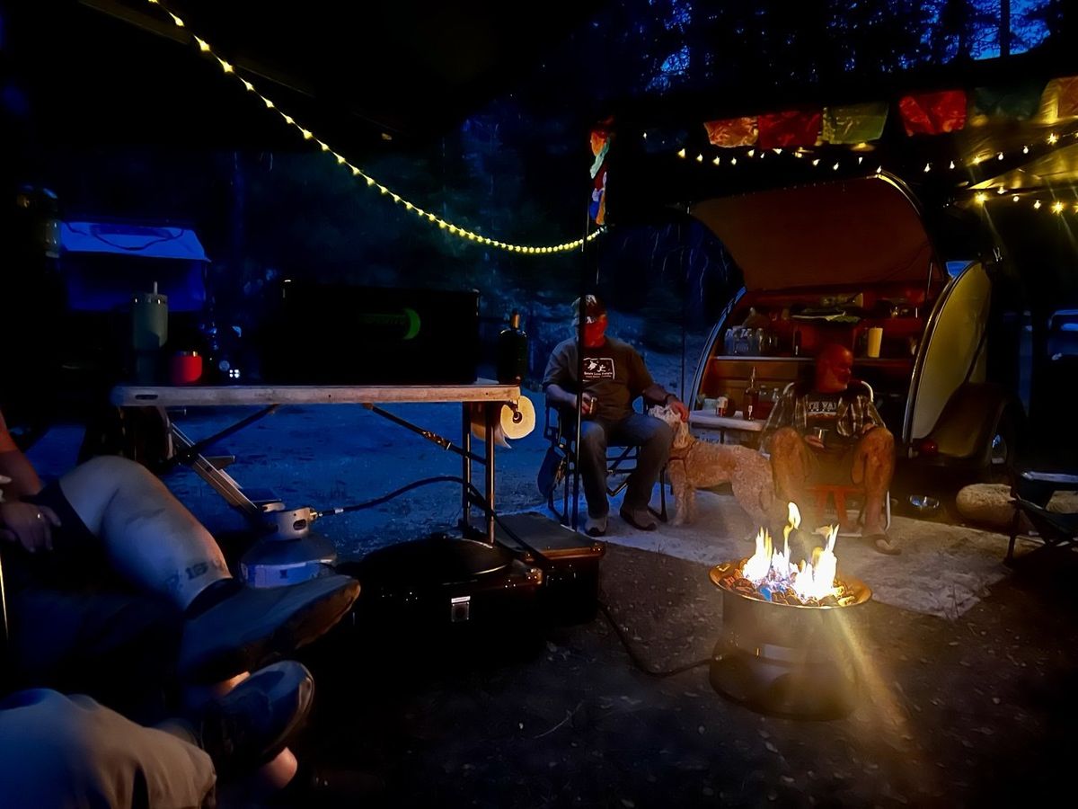 Night fire pit with camper van and strings of lights