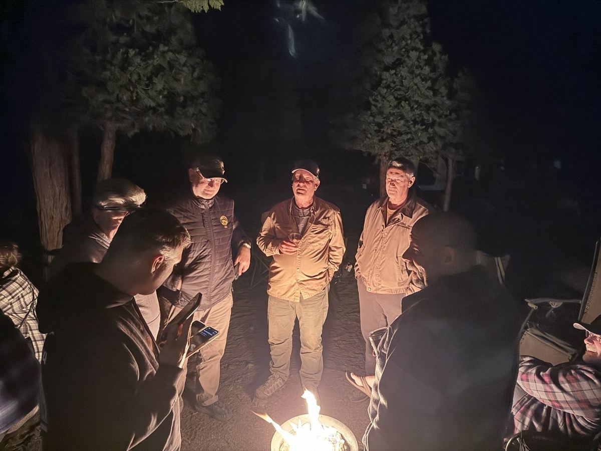 Group gathered around the fire pit under the night sky