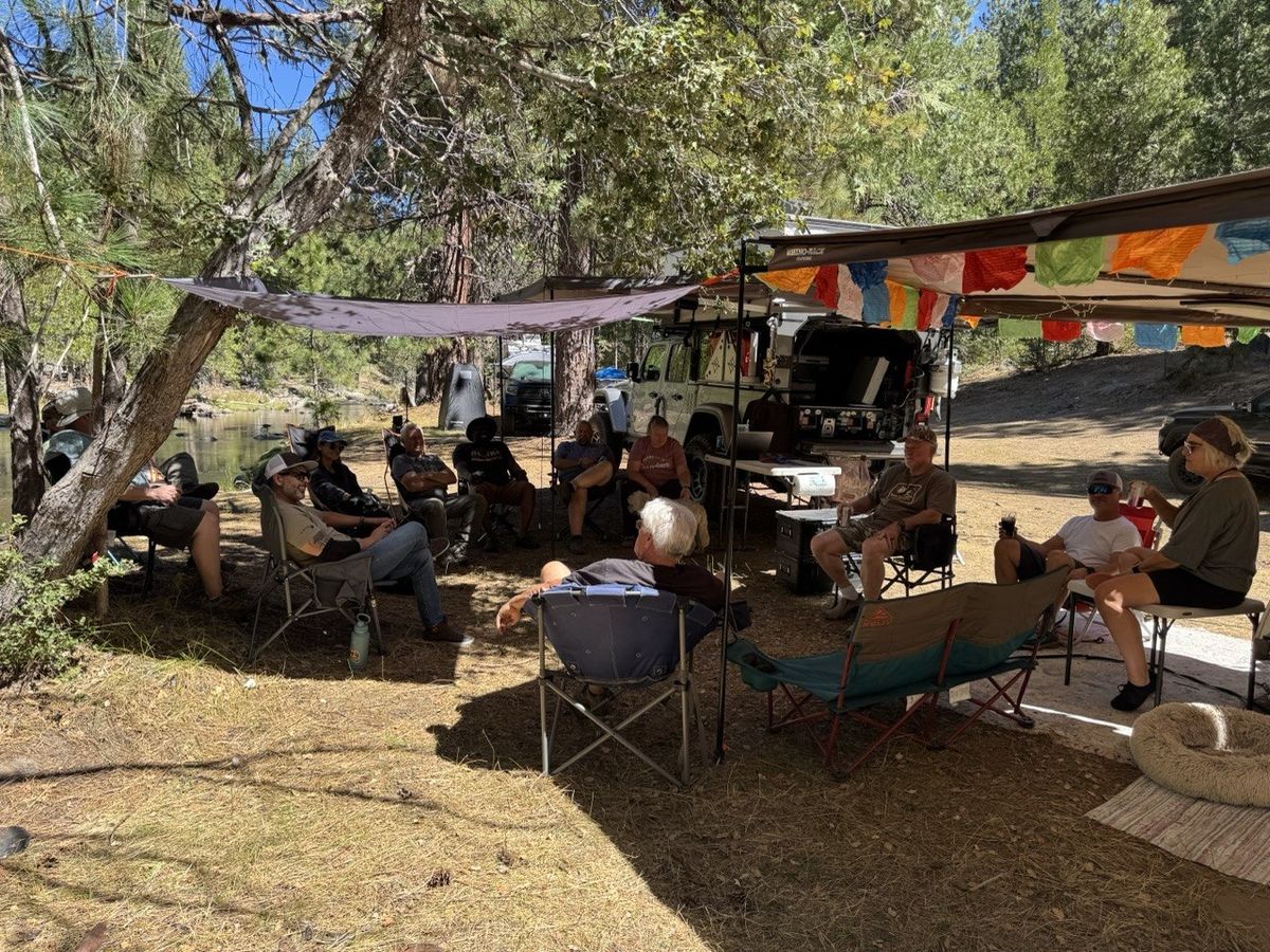 The group at the riverside basecamp under the pines